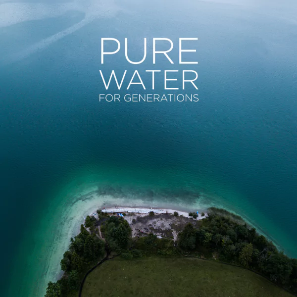 Luftaufnahme eines klaren Sees mit Insel und dem Slogan „Pure Water For Generations“